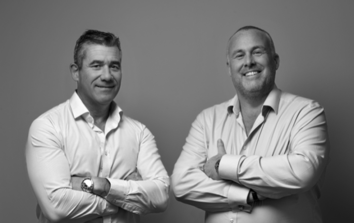 The image shows Paul Schofield (on the left) and Jon Newall (on the right) in a black and white photo, both smiling with their arms crossed. This follows the acquisition of Donald Schofield (Pontefract) Limited into the Prosura Group.