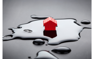 An image of a small red wooden house in a splash of water.