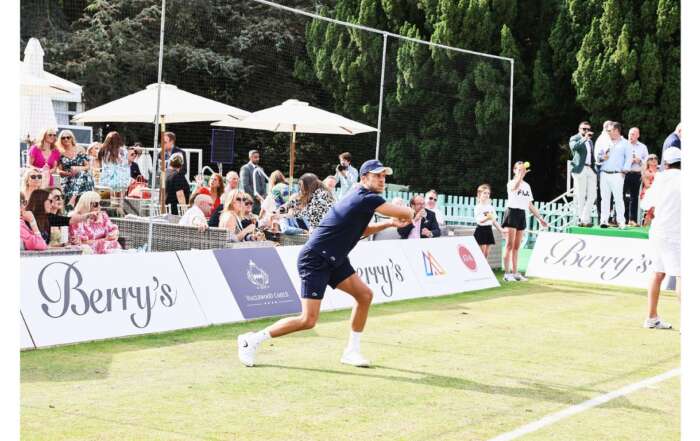 An action shot of a tennis player playing on court at Berry's Tennis event.